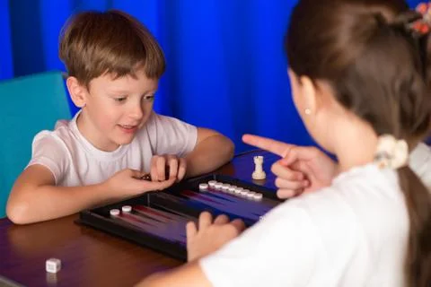 Boy and girl playing a board game called Backgammon Stock Photos