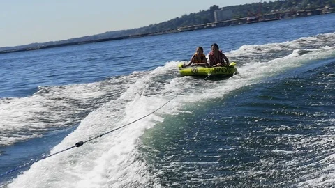 Boy and girl pulled on inner tube behind motorboat, Lake Washington, Seattle. Stock Footage 98011482