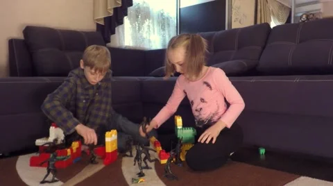 Boy and Girl Sitting playing on the floor with toy soldiers Video stock 68857504
