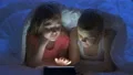 The boy and a girl using a tablet under the bed. evening night time 4k or 4k+ Resolution
