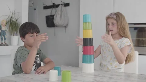 Boy and Girl Using Teamwork To Complete Cup Stacking Puzzle Together On Stock Footage 248413313