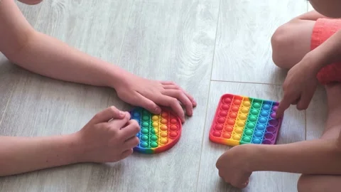 Boy and gril presses bubbles on morden silicone toy pop it. Anti stress sensory Stock Footage 155375718