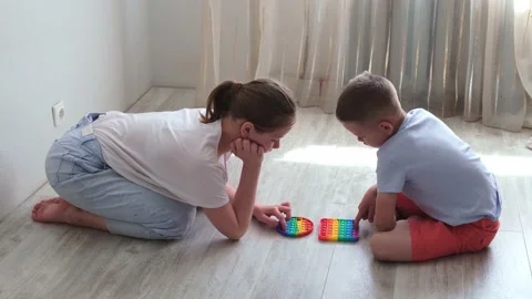 Boy and gril presses bubbles on morden silicone toy pop it. Anti stress sensory Stock Footage 156845023
