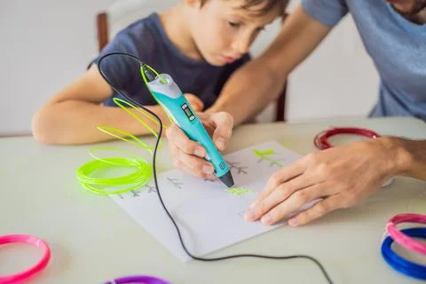 Boy and his father using 3d printing drawing pen. Creative, leisure, technology 스톡 사진