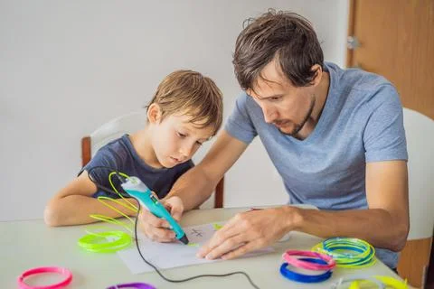 Boy and his father using 3d printing drawing pen. Creative, leisure, technology 스톡 사진