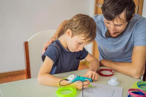 Boy and his father using 3d printing drawing pen. Creative, leisure, technology 스톡 사진