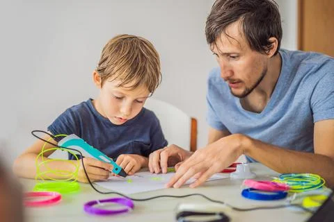 Boy and his father using 3d printing drawing pen. Creative, leisure, technology 스톡 사진