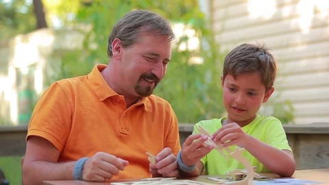 Boy and man collect model from the designer Stock Footage 75442770