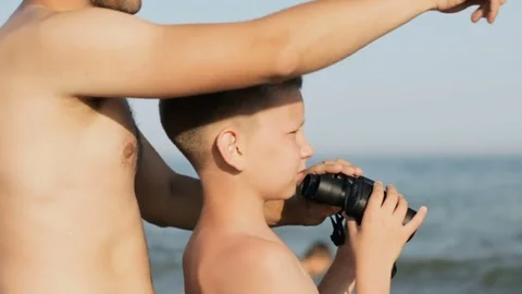 Boy and man lifeguard look through binoculars Stock Footage 82362424