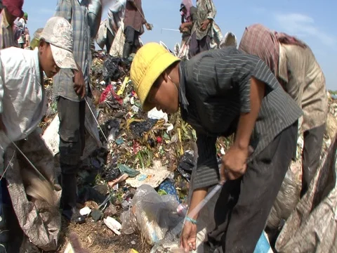 Boy and men picking through garbage on top of garbage dump Stock Footage 90271104