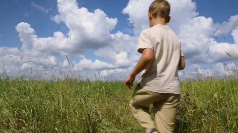 Boy and running through the field, from the camera Stock Footage 605607