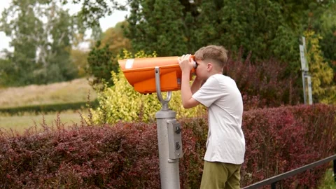 A boy and a telescope explore the nature of the park. Stock Footage 283466340