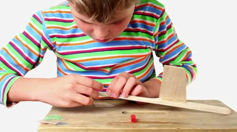 Boy apply adhesive and attach tail to wooden aircraft Video stock 8520175
