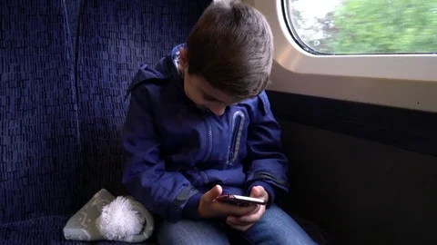 Boy are watching the smartphone on the train Vídeos de archivo 81755533