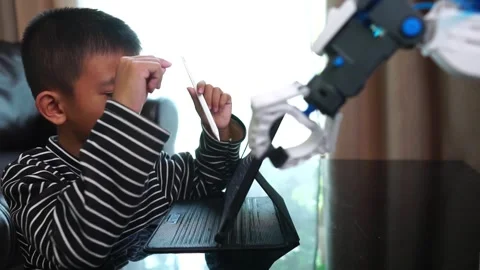 Boy asia constructs and programmes on computer and building a robot arm at home  Stock Footage 246185472