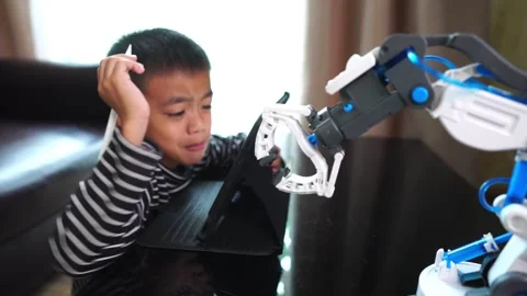 Boy asia control robot arm on Digital tablet Vídeo Stock 246182662