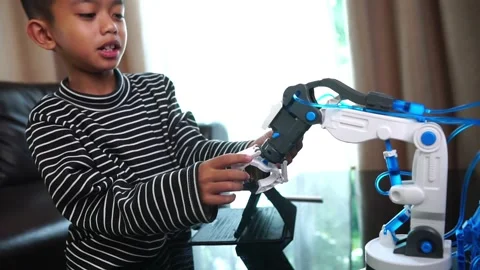 Boy asia control robot arm on Digital tablet Stock Footage 246185512