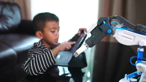 Boy asia control robot arm on Digital tablet Stock Footage 246186456