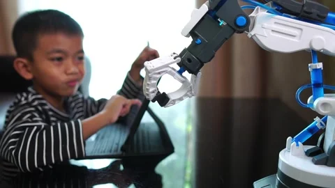 Boy asia control robot arm on Digital tablet Stock Footage 246187483
