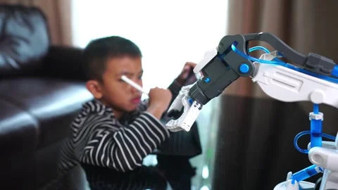 The boy asia programming a robot on his laptop Stock Footage 246185961