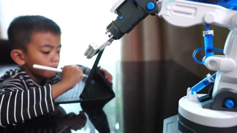 The boy asia programming a robot on his laptop Stock Footage 246186369