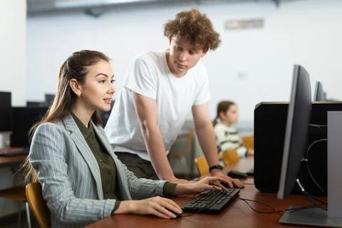 Boy asking teacher about computer problem during lesson Stock-Fotos