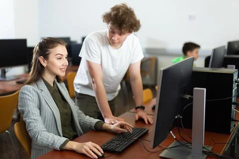 Boy asking teacher about computer problem during lesson 스톡 사진