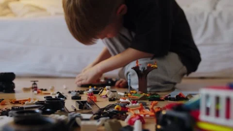 A boy assembles a car from a construction set Stock Footage 252382424