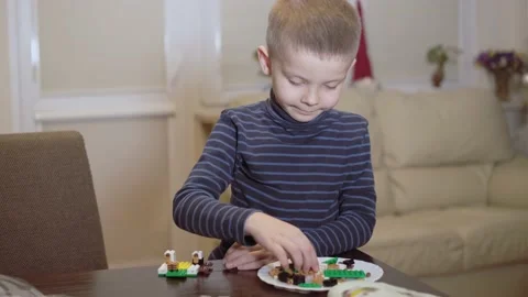 The boy assembles the construction set at home. Видео 225496943