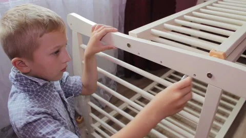 A boy assembles a cradle Stock Footage 296583902