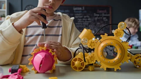 Boy Assembling Robot Model with Screwdriver in Stem Class Stock Footage 339193792
