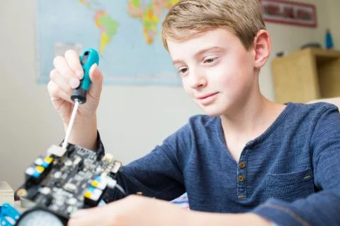 Boy Assembling Robotic Kit In Bedroom Foto stock