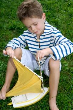 Boy assembling toy boat Stock Photos