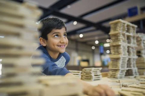 Boy assembling wood block structure at science center Foto stock
