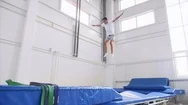 A Boy Athlete Does A Back Flip On The Trampoline In Gym, Slow Motion. Side View. Stock Footage