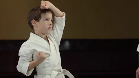 Boy athlete performs blocks with his hands under the control of a trainer Stock-Footage 301507321