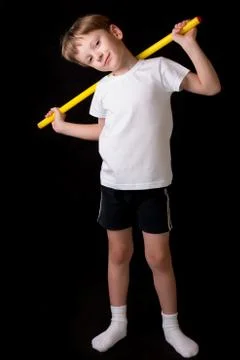 Boy athlete performs exercises with gymnastic stick in the gym Stock Photos
