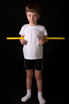 Boy athlete performs exercises with gymnastic stick in the gym Stock-Fotos