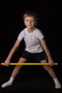 Boy athlete performs exercises with gymnastic stick in the gym Foto stock