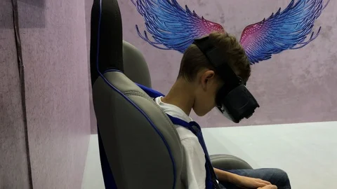 Boy in augmented reality glasses on virtual reality chair Stock Footage 96986193