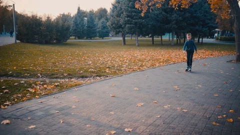 Boy in the autumn park rollerblading Video stock 119258444