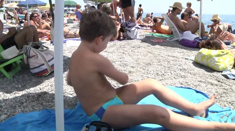 Boy on the bach under umbrella. Stock Footage 30346771