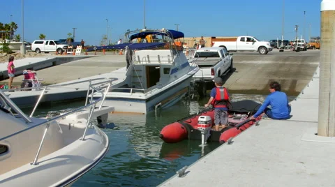 Boy back out a small boat from the boat dock in the marina. Stock-Footage 51431676