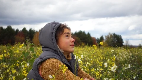 A boy on the background of a paradoxical flowering field in the fall. Video stock 99040163