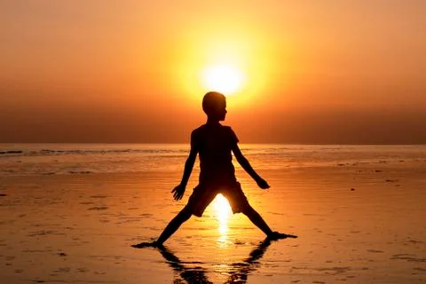 Boy in backlight in sunset with sun in background Stock Photos