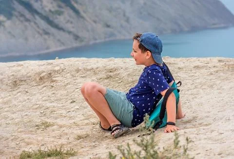 A boy with a backpack 10 years old fell and laughs. Stock-Fotos