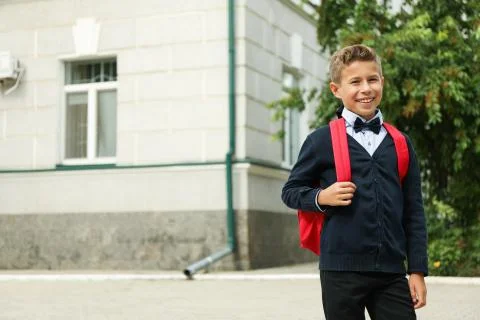 Boy with backpack against school building, space for text Fotos de archivo