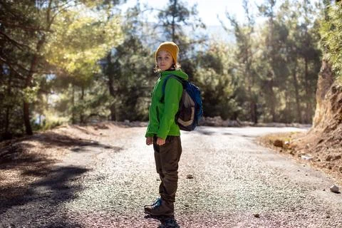 Boy with a backpack in the forest. The child is standing in the middle of the Stock Photos