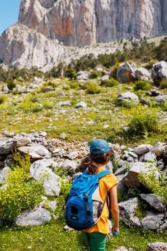 Boy with a backpack on a hike against the backdrop of the mountains. child tr Stock Photos