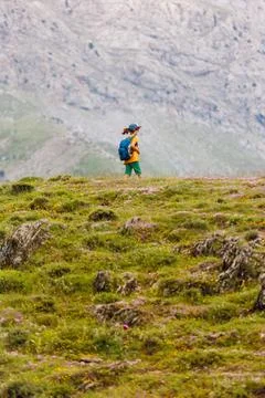 Boy with a backpack on a hike against the backdrop of the mountains. child tr Stock Photos